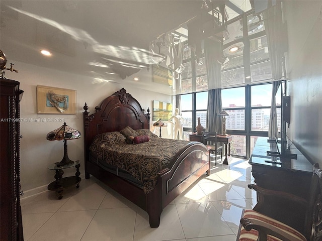 bedroom with light tile patterned floors, a towering ceiling, and expansive windows