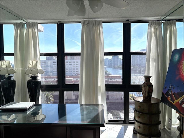 office space featuring a water view, a textured ceiling, and a wall of windows