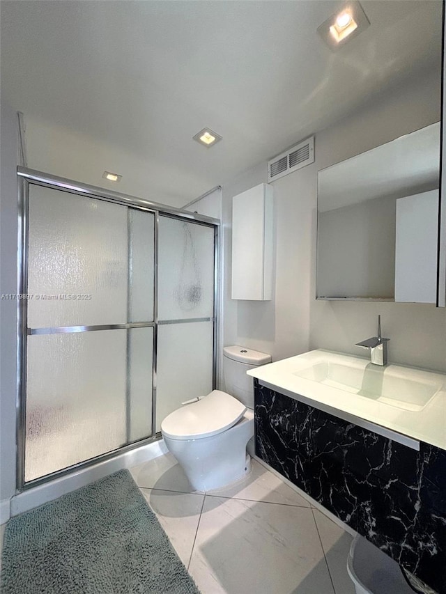 bathroom featuring vanity, an enclosed shower, and toilet