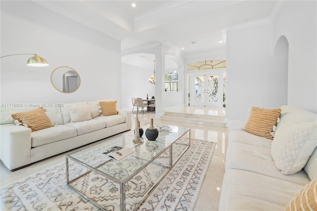 living room featuring french doors, a chandelier, and ornamental molding