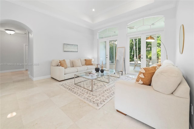 living room featuring french doors, ornamental molding, and a tray ceiling