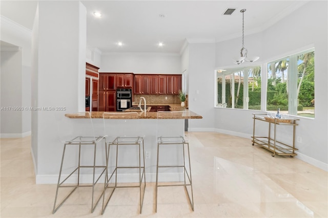 kitchen with decorative backsplash, hanging light fixtures, ornamental molding, and kitchen peninsula