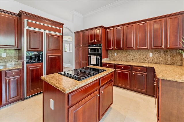 kitchen with light stone countertops, black appliances, a center island, and tasteful backsplash