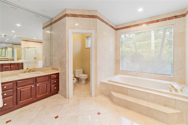 full bathroom with tile walls, toilet, a bidet, and shower with separate bathtub