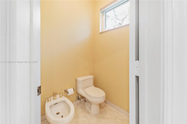 bathroom with a bidet, tile patterned floors, and toilet