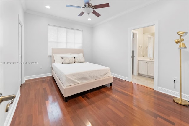 bedroom featuring crown molding, dark wood-type flooring, ensuite bathroom, and ceiling fan