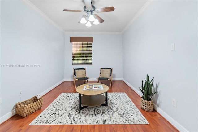 living area with hardwood / wood-style floors, ceiling fan, and ornamental molding