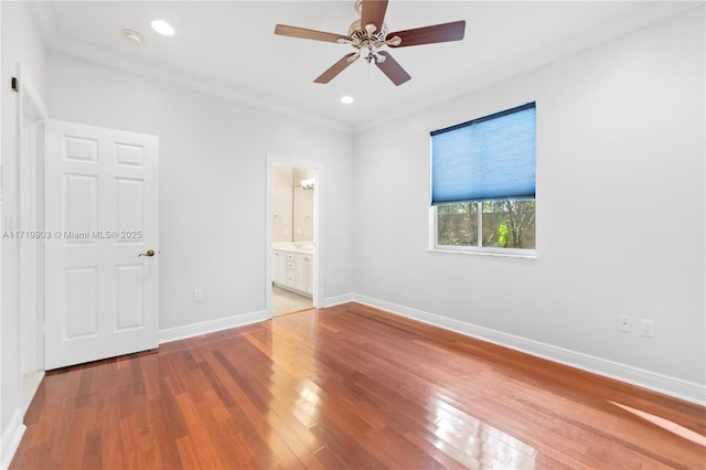 spare room with crown molding, wood-type flooring, and ceiling fan