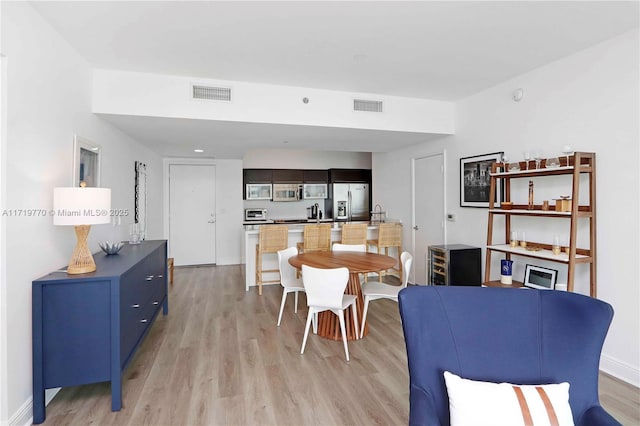 dining area featuring light wood-type flooring and sink