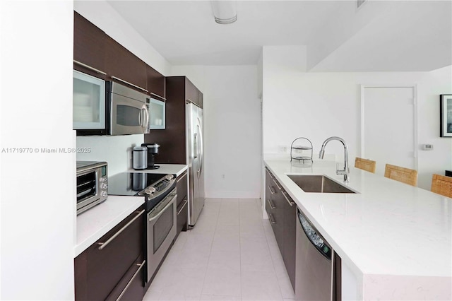 kitchen featuring light tile patterned flooring, sink, and stainless steel appliances