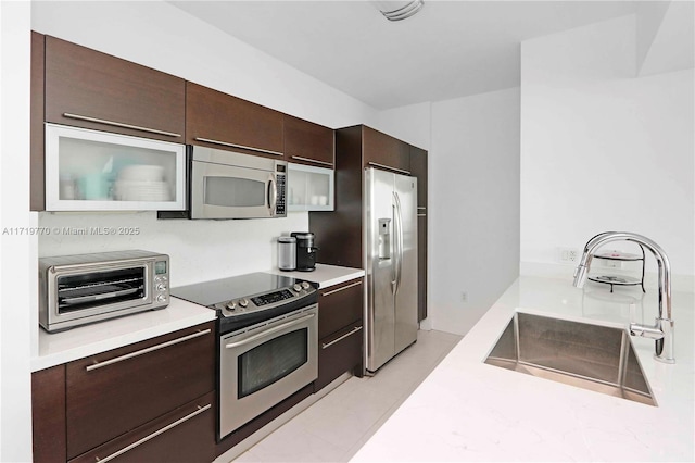 kitchen with sink, dark brown cabinets, and appliances with stainless steel finishes