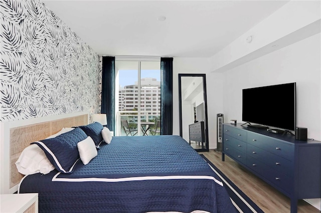 bedroom with dark hardwood / wood-style floors and expansive windows