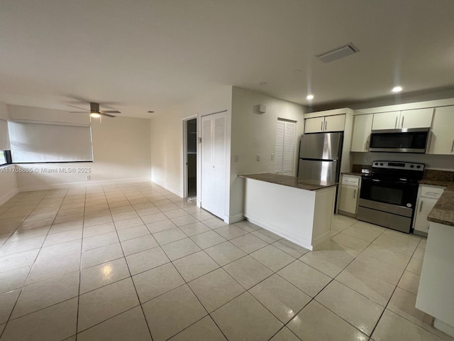 kitchen featuring white cabinetry, ceiling fan, light tile patterned flooring, and stainless steel appliances