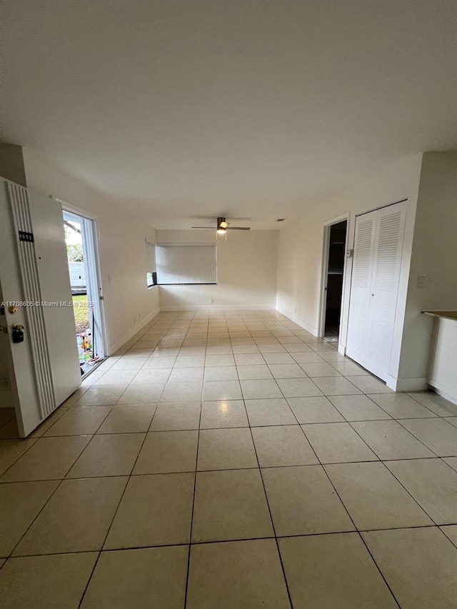 tiled empty room featuring ceiling fan