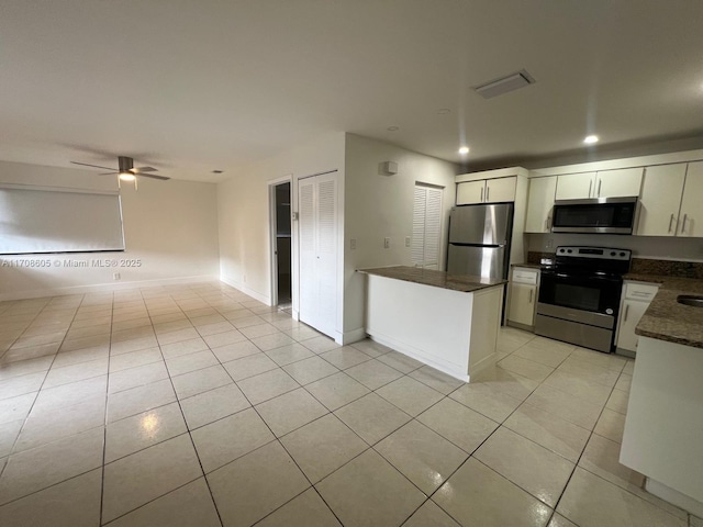 kitchen featuring ceiling fan, white cabinetry, stainless steel appliances, and light tile patterned floors