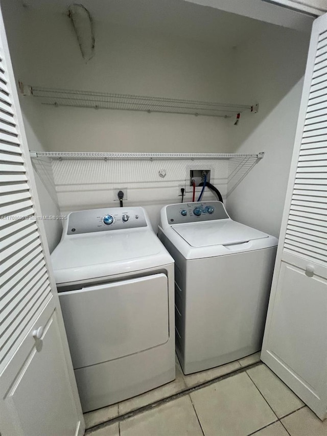 laundry area with light tile patterned floors and washing machine and dryer