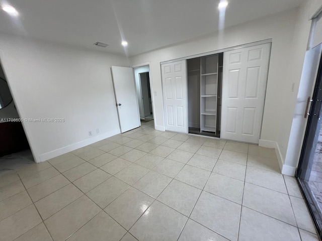 unfurnished bedroom with a closet and light tile patterned floors