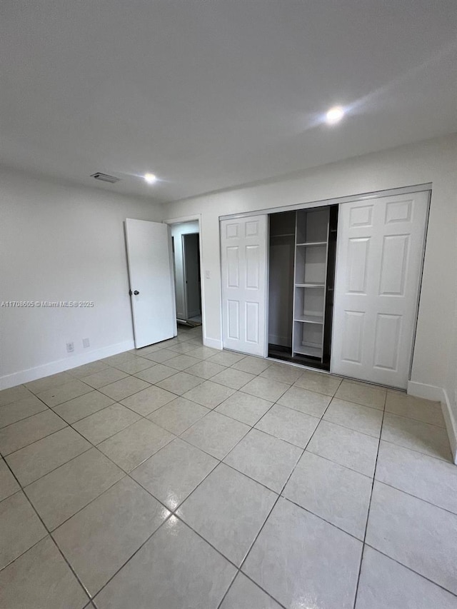 unfurnished bedroom featuring light tile patterned floors and a closet