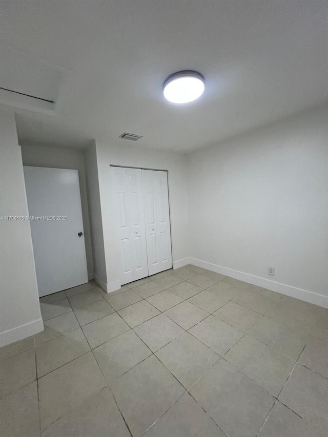 unfurnished bedroom with a closet and light tile patterned flooring