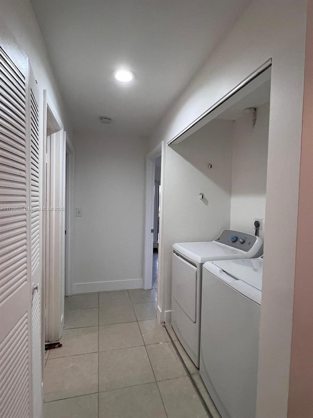 laundry area with washer and clothes dryer and light tile patterned floors