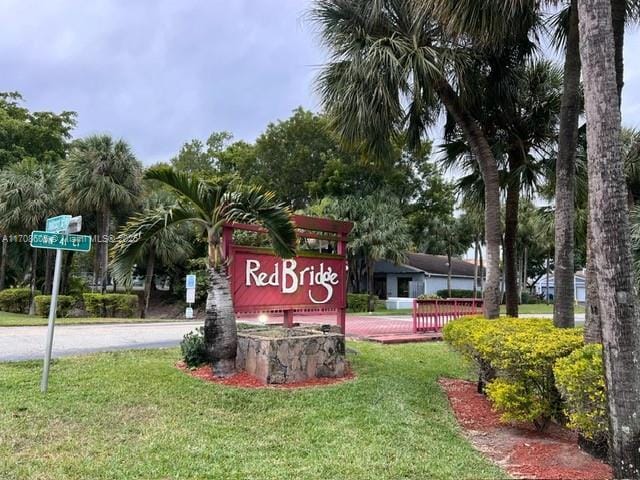 community / neighborhood sign featuring a yard