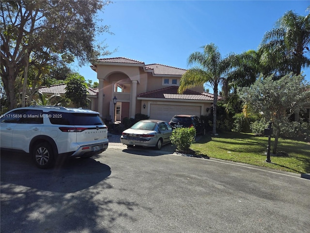 mediterranean / spanish-style home with a front yard and a garage