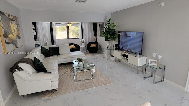 living room featuring ceiling fan and a textured ceiling