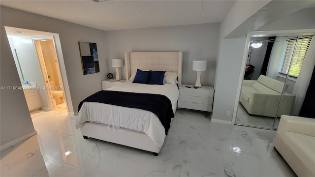 bedroom with ensuite bath, a closet, and a textured ceiling