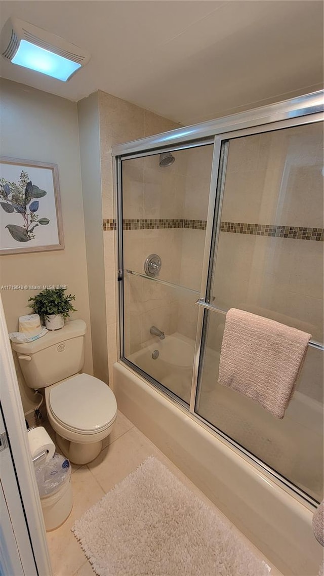 bathroom with tile patterned flooring, toilet, and enclosed tub / shower combo