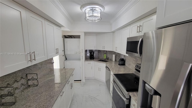 kitchen with white cabinets, stacked washer and dryer, appliances with stainless steel finishes, and tasteful backsplash