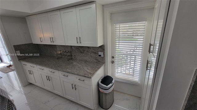 kitchen with white cabinets, backsplash, and stone counters