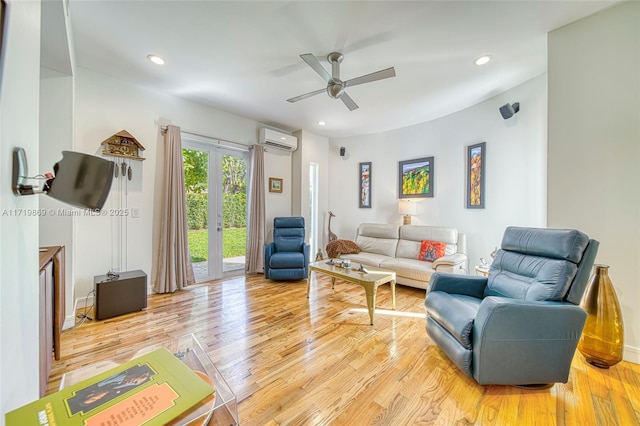 living room featuring an AC wall unit, ceiling fan, french doors, and light hardwood / wood-style floors