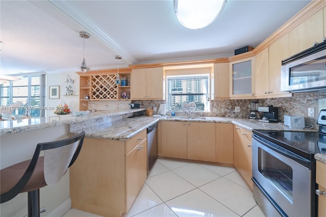 kitchen with crown molding, light brown cabinets, hanging light fixtures, and appliances with stainless steel finishes