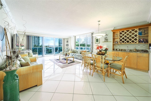 dining space featuring bar area, crown molding, light tile patterned floors, and a wall of windows