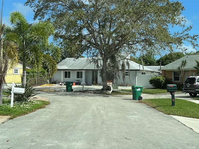 view of front of property with driveway and fence