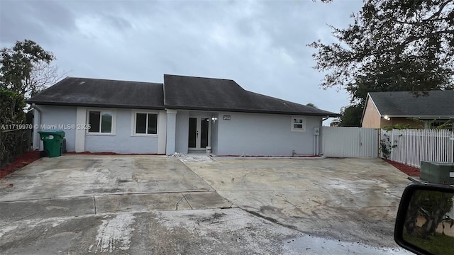 back of house with fence and stucco siding