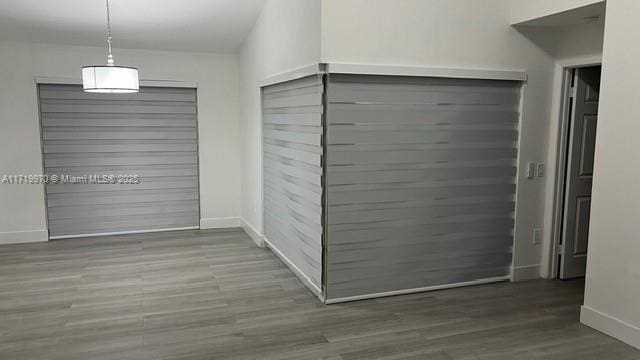 unfurnished dining area featuring wood finished floors and baseboards