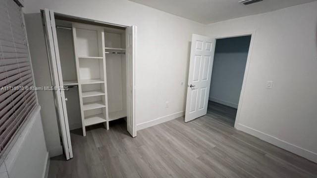 unfurnished bedroom with hardwood / wood-style flooring and a closet