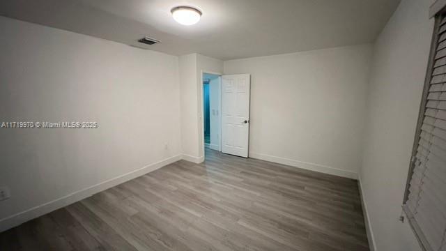 spare room with hardwood / wood-style floors