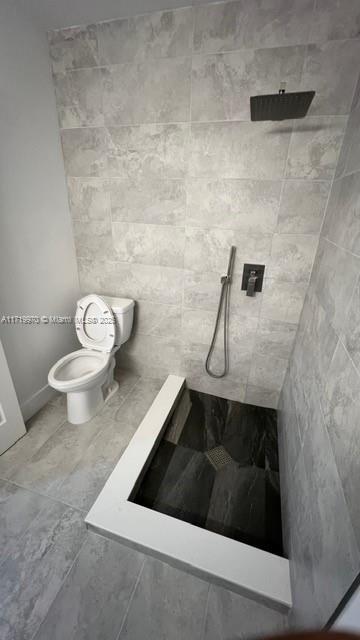 bathroom featuring a shower and toilet