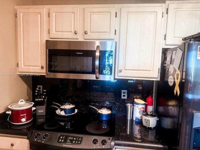 kitchen featuring white cabinets and black refrigerator