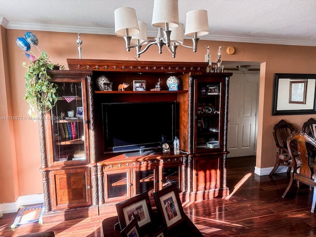 living room featuring a chandelier, wood-type flooring, a textured ceiling, and ornamental molding