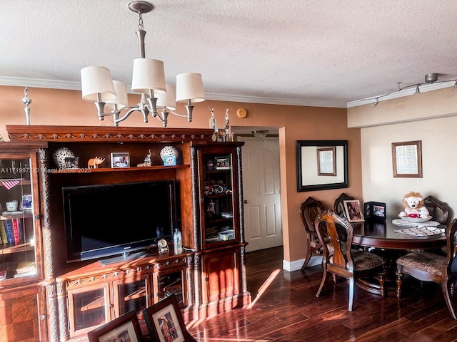 dining space with dark hardwood / wood-style flooring, ornamental molding, a textured ceiling, and a chandelier