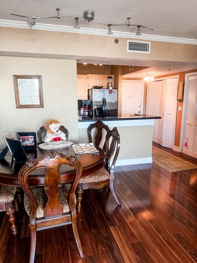 dining space featuring sink, dark hardwood / wood-style floors, crown molding, and a textured ceiling