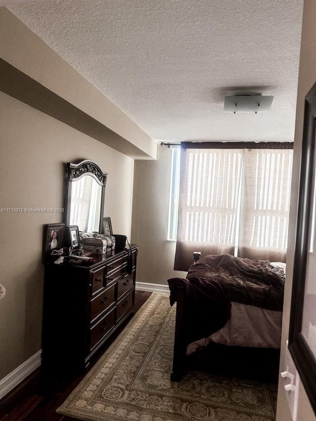 bedroom featuring dark hardwood / wood-style flooring and a textured ceiling