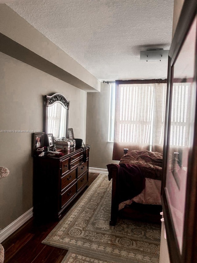 bedroom featuring dark hardwood / wood-style floors and a textured ceiling