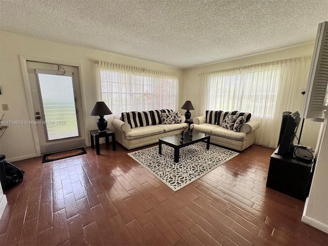 living room featuring dark wood-type flooring and a textured ceiling