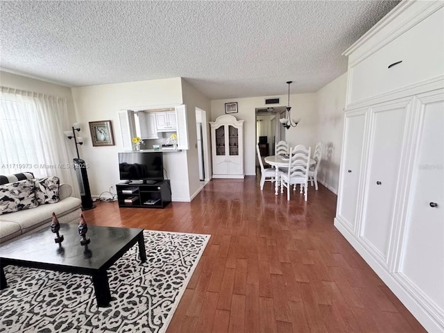 living room with a textured ceiling and dark hardwood / wood-style flooring