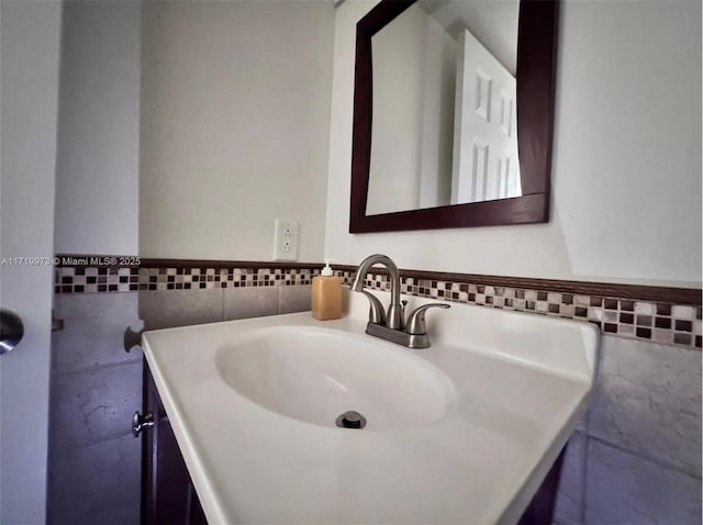 bathroom with vanity and tile walls