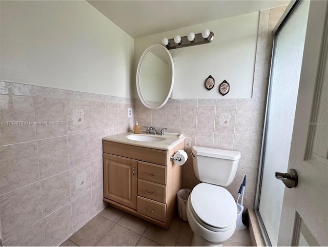 bathroom with tile patterned floors, vanity, toilet, and tile walls